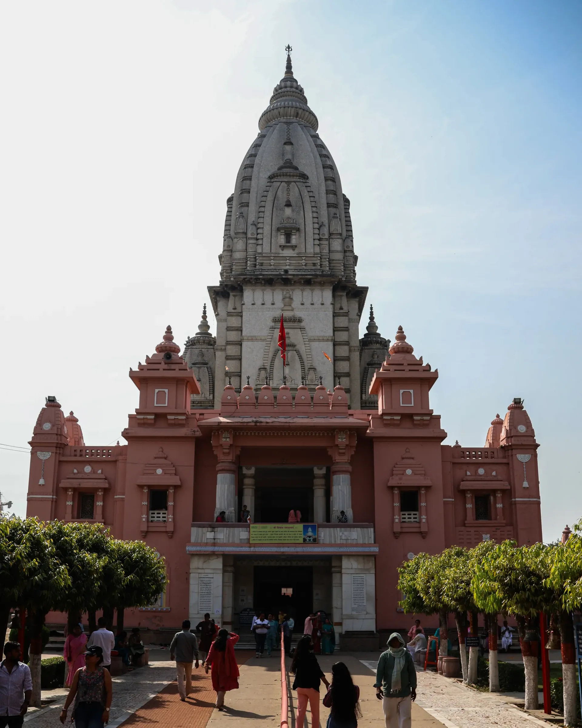 Front view of a temple spire in Varanasi with pilgrims walking toward it