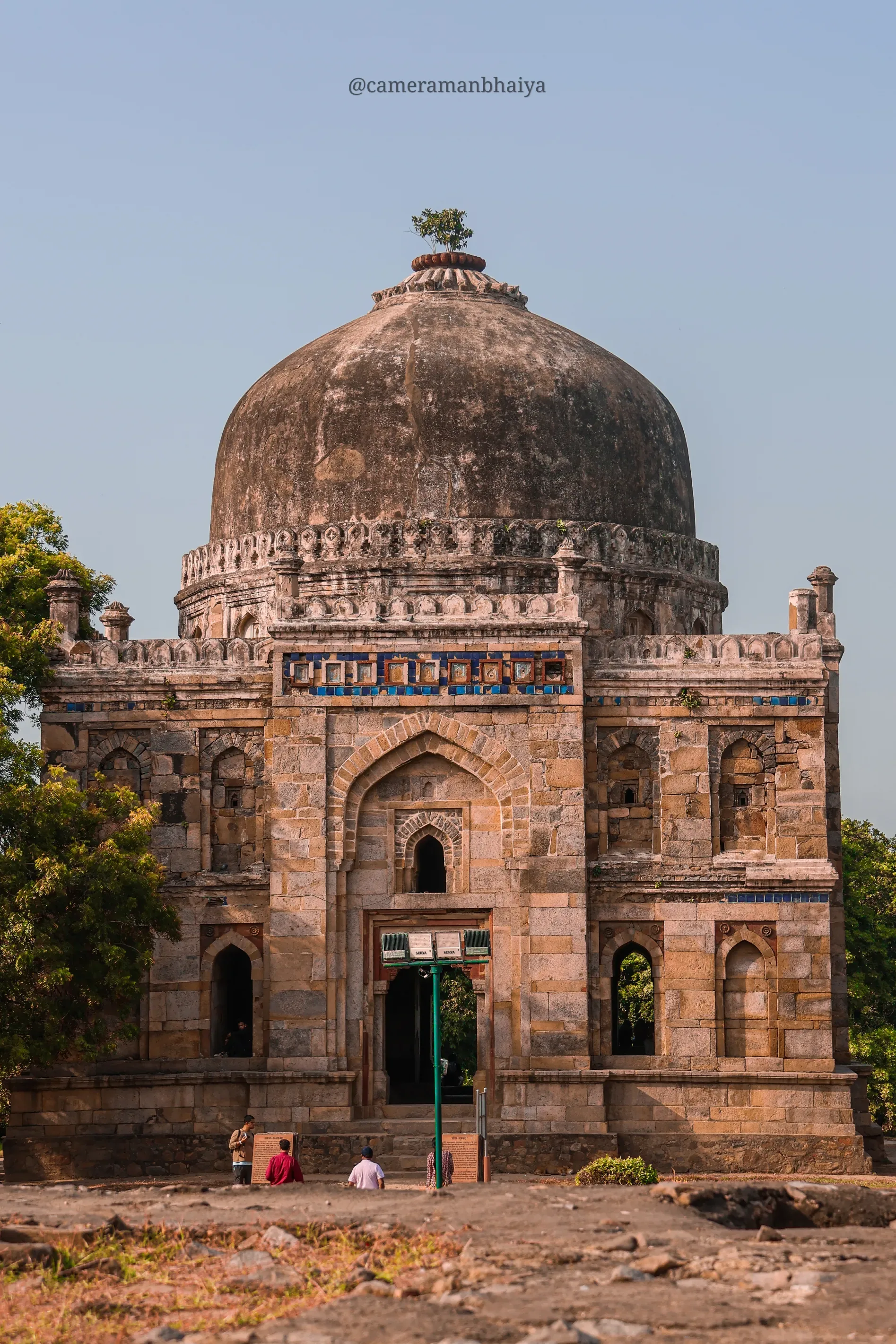 Front facade of a Lodi era tomb in Delhi with visitors on the steps