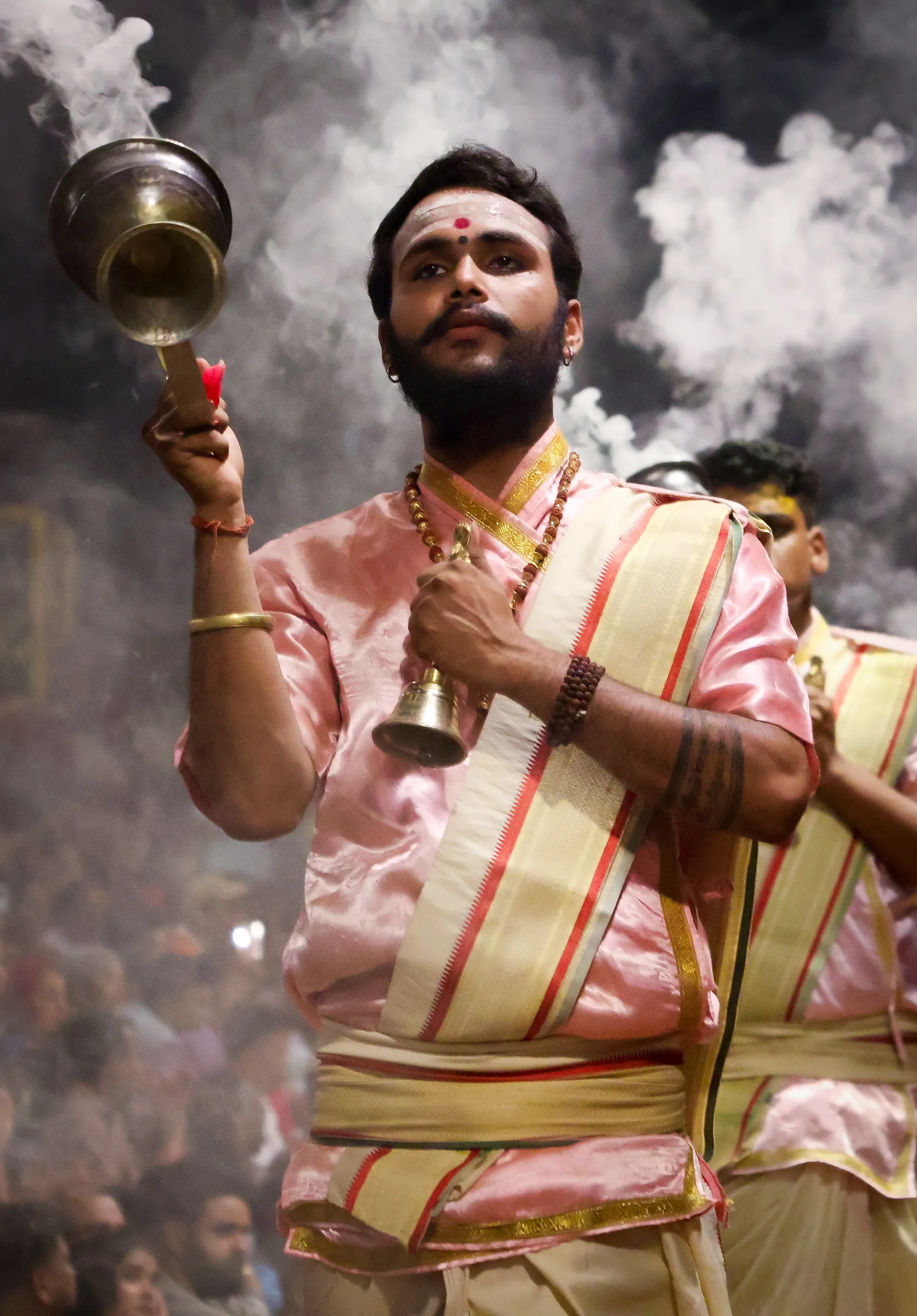 Priest ringing a bell during evening aarti ceremony